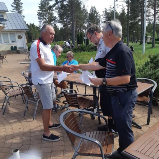 Kaakkois-Suomen aluekoordinaattori Imatran Ossi Sorjonen palkitsee sarjan M60 voittajan Koski Golfin Matti Mäkelän yhdessä kilpailun johtajan kanssa.