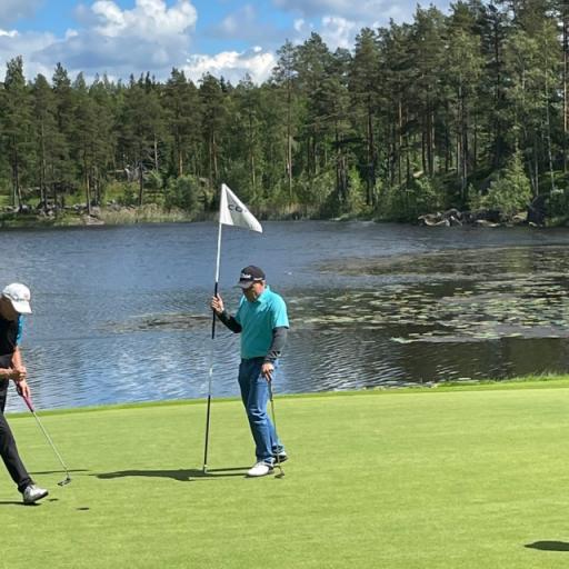 Tour Manager tuulettaa onnistunutta par puttia väylällä 12. Ossi Smolander tarkkailee.