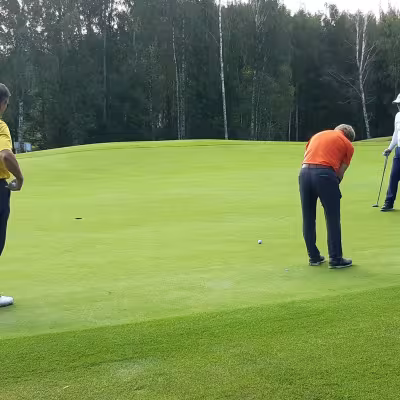Veijo Suomela (vas.) ja Ari Vauhkonen (oik.) seuraavat, kun Reijo Alanko upottaa puttinsa 1. reiällä.