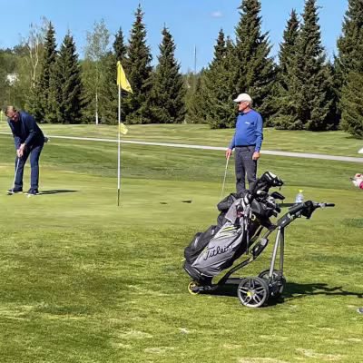  Arto Tikkanen puttaamassa 18. reiällä, Martti Raunio ja Heikki Hallanoron caddie tarkkailevat.