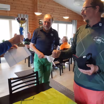 Aluekoordinaattori luovuttaa kiertopalkinnon PGK:n joukkueelle (Virtanen ja Savinen)