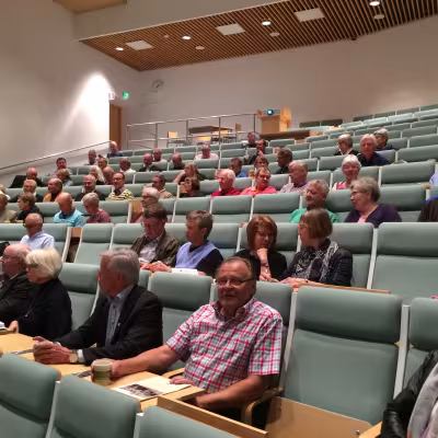 Kokousväkeä hiljentymässä ennen tilaisuutta